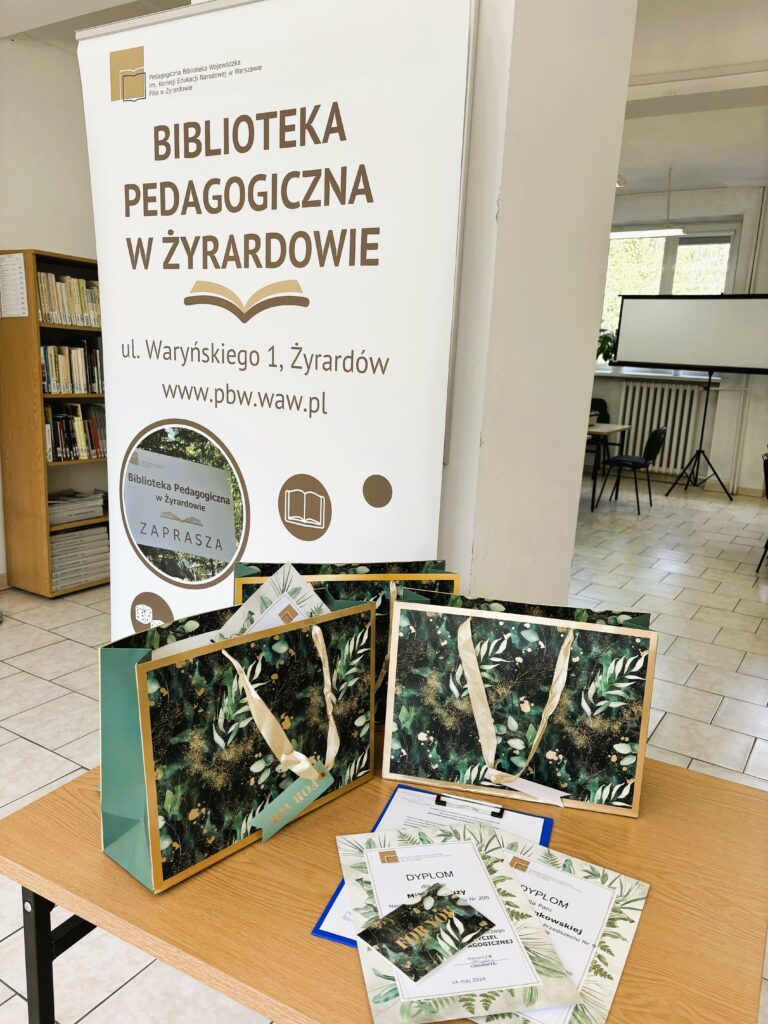 Obraz przedstawiający rollup biblioteki oraz dyplomy i nagrody w konkursie.